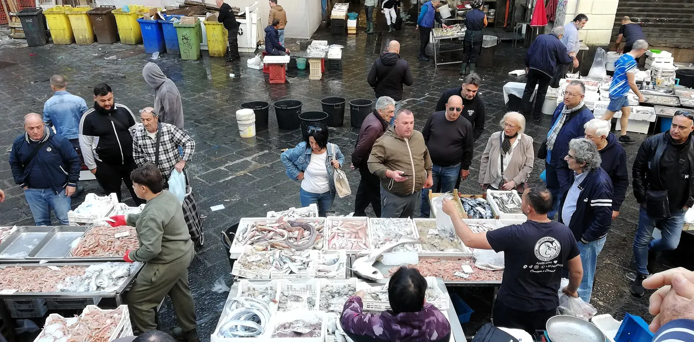 Stalls and shoppers at Catania's fish market in the morning